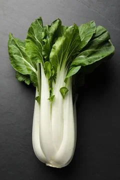 Fresh green pak choy cabbage on black table, top view Stock Photos