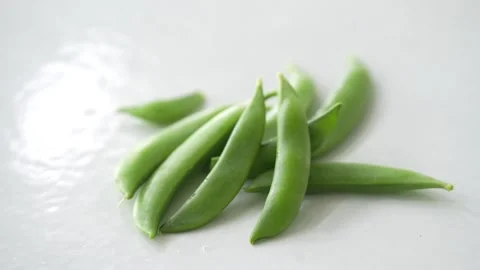 Fresh green pea pods arranged on a white background Stock Footage 339067892