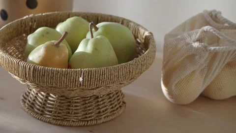 Fresh green pears in wicker basket with eco friendly mesh bag on wooden tab.. Stock-Footage 332108926