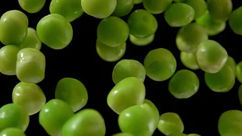Fresh green peas bouncing up and down on the black background Stock Footage 314889714