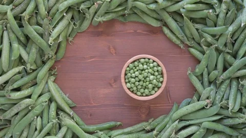 Fresh green peas on rustic wooden table. Stock Footage