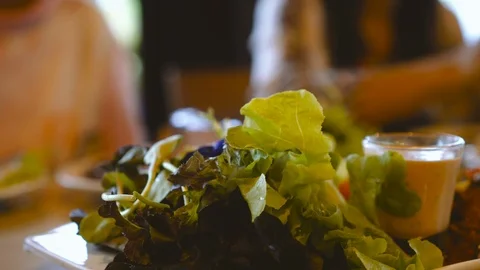 Fresh green salad while asian old woman pouring sauce in restaurant. Stock Footage 91925562