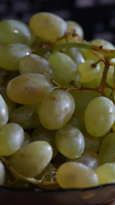 Fresh green seedless grapes bunch served in dark bowl indoor. Video stock 343755066