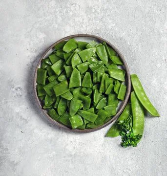 Fresh green string beans in a gray plate on a light gray background top view Foto stock