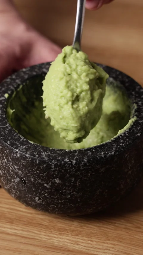 Fresh Guacamole on Spoon Close Up Vertical Front View Видео 336572130
