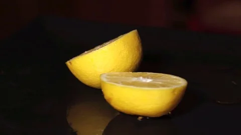 Fresh Half Cut Lemon Rotating On Black Plate Stock-Footage 79843752