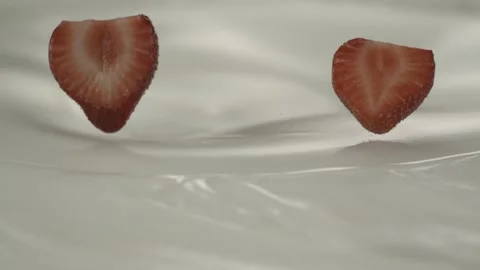 Fresh half sliced strawberries fall on yogurt – Close up Stock Footage 161526713