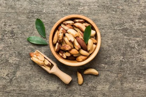 Fresh healthy Brazil nuts in bowl on colored table background. Top view Healt Stock Photos