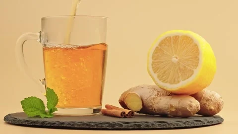 Fresh herbal tea with ginger, lemon, mint and cinnamon on a slate board Stock Footage 318890610