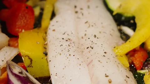 Fresh herbs falling in slow motion onto wild caught atlantic Cod fillets with Stock Footage 328834719