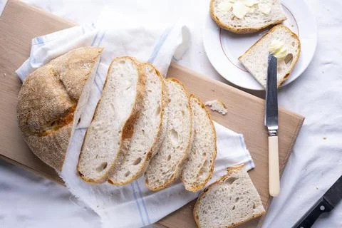 Fresh homemade baked bread and sliced bread on rustic white wooden table Stock Photos
