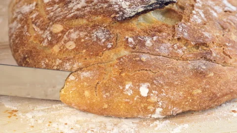 Fresh homemade bread. Cutting crispy artisan bread in the kitchen with a knife. Stock Footage 197433204
