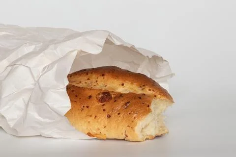 Fresh homemade bread, partially broken, is visible in a white paper bag aga.. Stock Photos