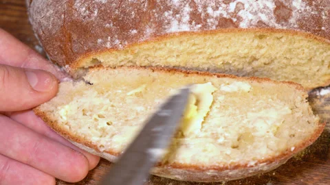 Fresh homemade bread spread with butter Stock Footage 252459635