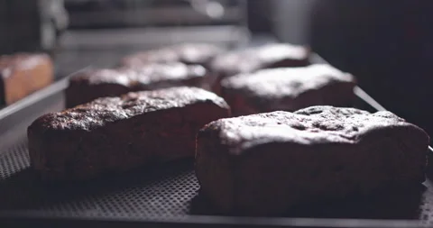 Fresh hot bread comes out of the oven on a conveyor belt. Baker spraying breads 스톡 동영상 153119149