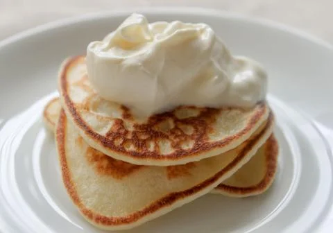 Fresh hot flapjack pancakes stack on white plate on natural light linen table Stock Photos