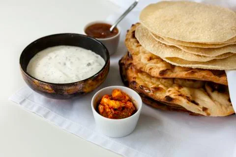 Fresh Indian flat breads served with raita, pickle and mango chutney Фото