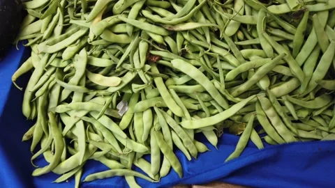 Fresh juicy green string beans on blue bazaar or shop counter. Close-up. Vidéo 135268507