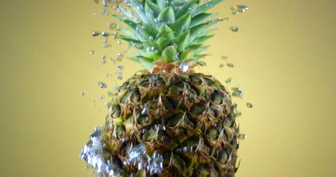 Fresh juicy pineapple rotating under water with air bubbles rising. Slow motion Stock Footage 151785573