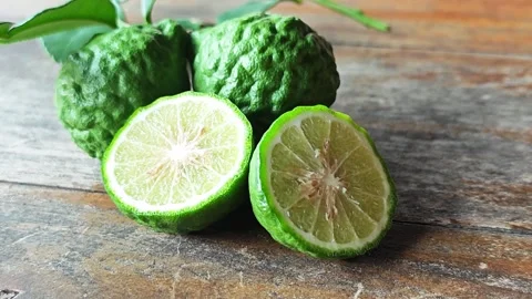Fresh kaffir lime cut in half on wooden background. Stock Footage 339204559