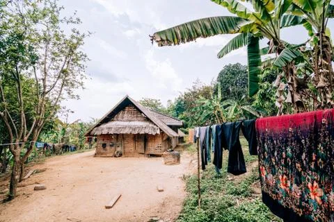 Fresh laundry drying in front of the traditional Laotian bamboo hut in a vill Stock Photos