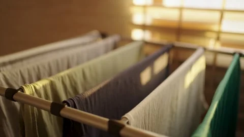 Fresh laundry drying on a rack in warm sunset light at home. Close-up of va.. Stock Footage 332161942