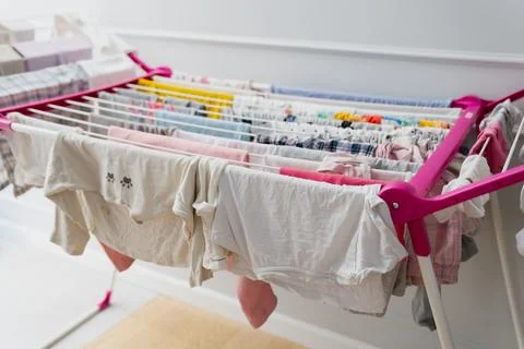 Fresh laundry hangs from a drying rack indoors Foto stock