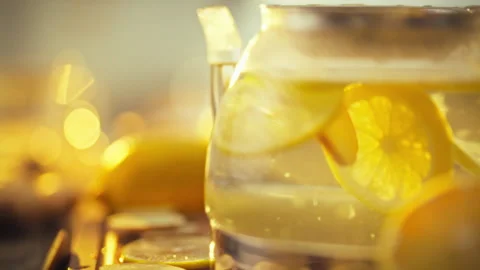 Fresh lemon and ginger slices dance in a teapot infused in hot water as citr Stock Footage 331351087