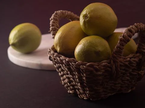 Fresh lemon in basket over black background Stock Photos