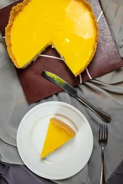 Fresh Lemon Cheesecake slice with fork and knife served in plate isolated o.. Stock Photos