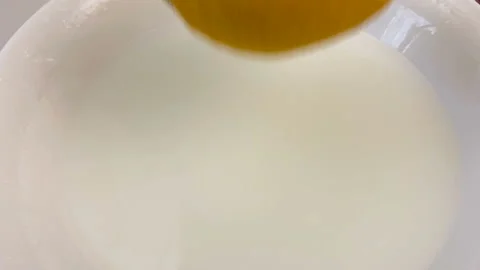 Fresh lemon fall down in plate with milk, closeup, super slow motion Stock Footage 132780451