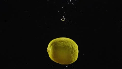 Fresh lemon falling deeply under water with big splash isolated over black Stock Footage 293086012