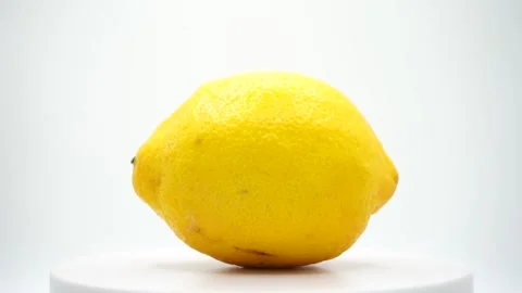 A fresh lemon rotates gracefully on a platform Stock Footage 289758241