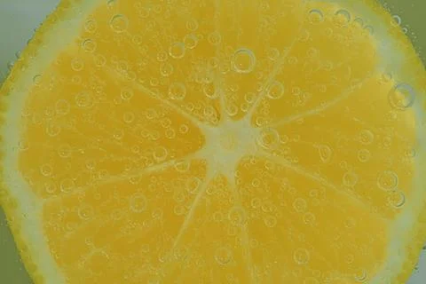 Fresh lemon slice in liquid with bubbles. Close-up of a lemon slice in soda Stock-Fotos