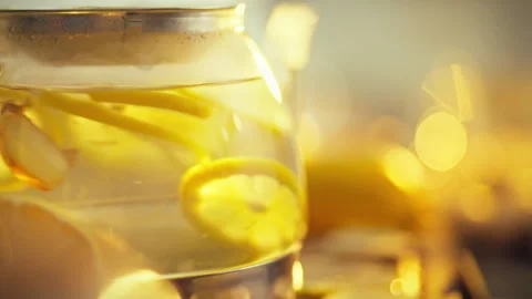 Fresh lemon slices ginger roots delicately float in teapot as steaming hot w Stock Footage 331347959