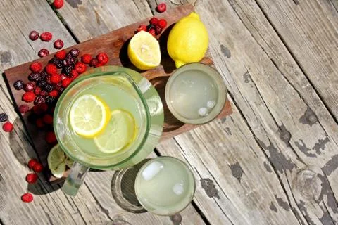 Fresh lemonade and fruit framing rustic wood background Stock Photos
