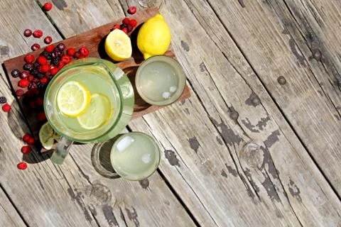 Fresh lemonade and fruit framing rustic wood background Stock Photos