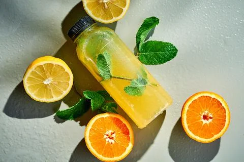 Fresh lemonade in composition with orange and lemon. Gray background. Mocap.  Stock Photos