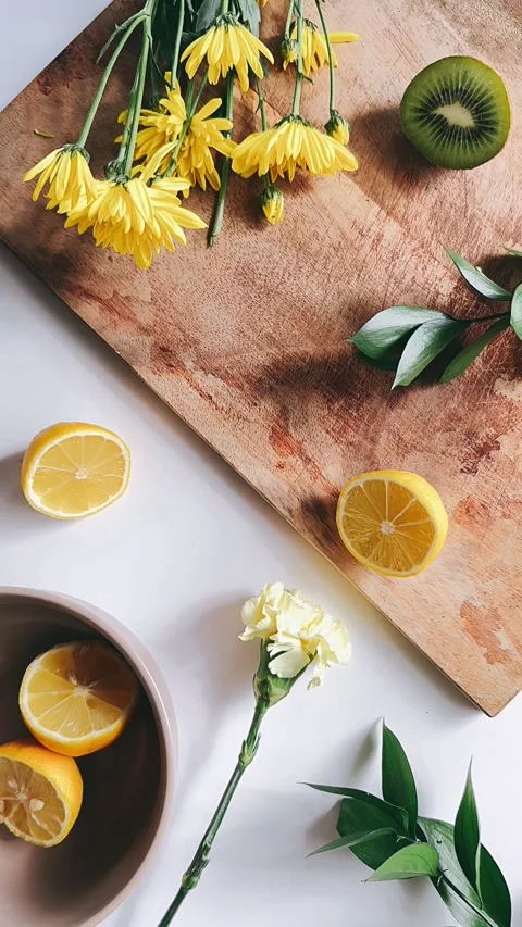 Fresh lemons, complemented by yellow flowers and green plants, Stock Footage 273269538