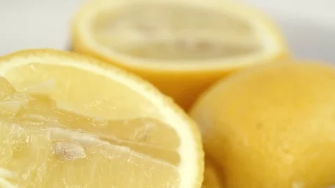 Fresh lemons falling on a white background. Closeup shot in slow motion Stock Footage 73345593