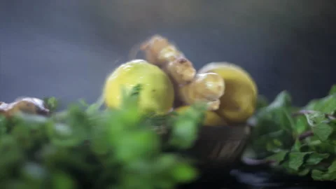 Fresh lemons, ginger coriander, some mint leaves on  shiny wooden surface. Stock Footage 231323779