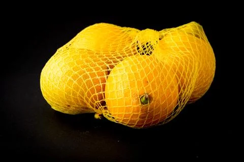Fresh lemons isolated in net ready for sale Stock Photos