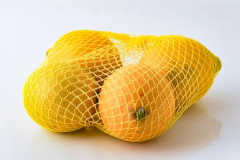 Fresh lemons isolated in net ready for sale Foto stock