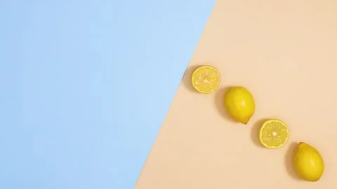 Fresh lemons move on blue and sandy background. Summer citrus stop motion Stock Footage 151935964