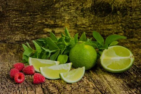 Fresh lime and raspberry on rustic wooden surface Stock Photos
