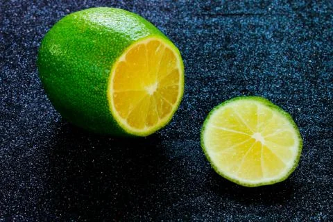 Fresh lime close-up cut in half on a black background. Stock Photos