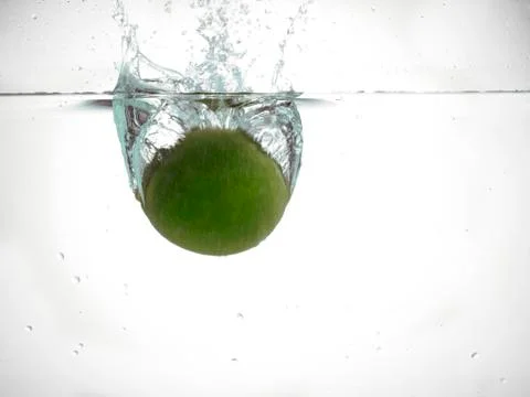 Fresh lime falling into water Foto stock