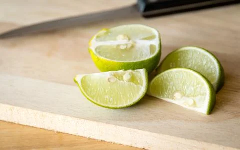 Fresh lime slice on chopping block with  knife Stock Photos
