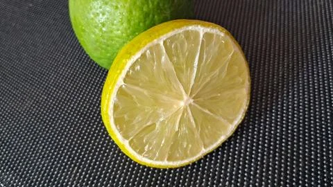 Fresh lime slice on dark background. Citrus fruit half for healthy food and Stock Photos