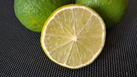 Fresh lime slice on dark background. Citrus fruit half for healthy food and Stock-Fotos